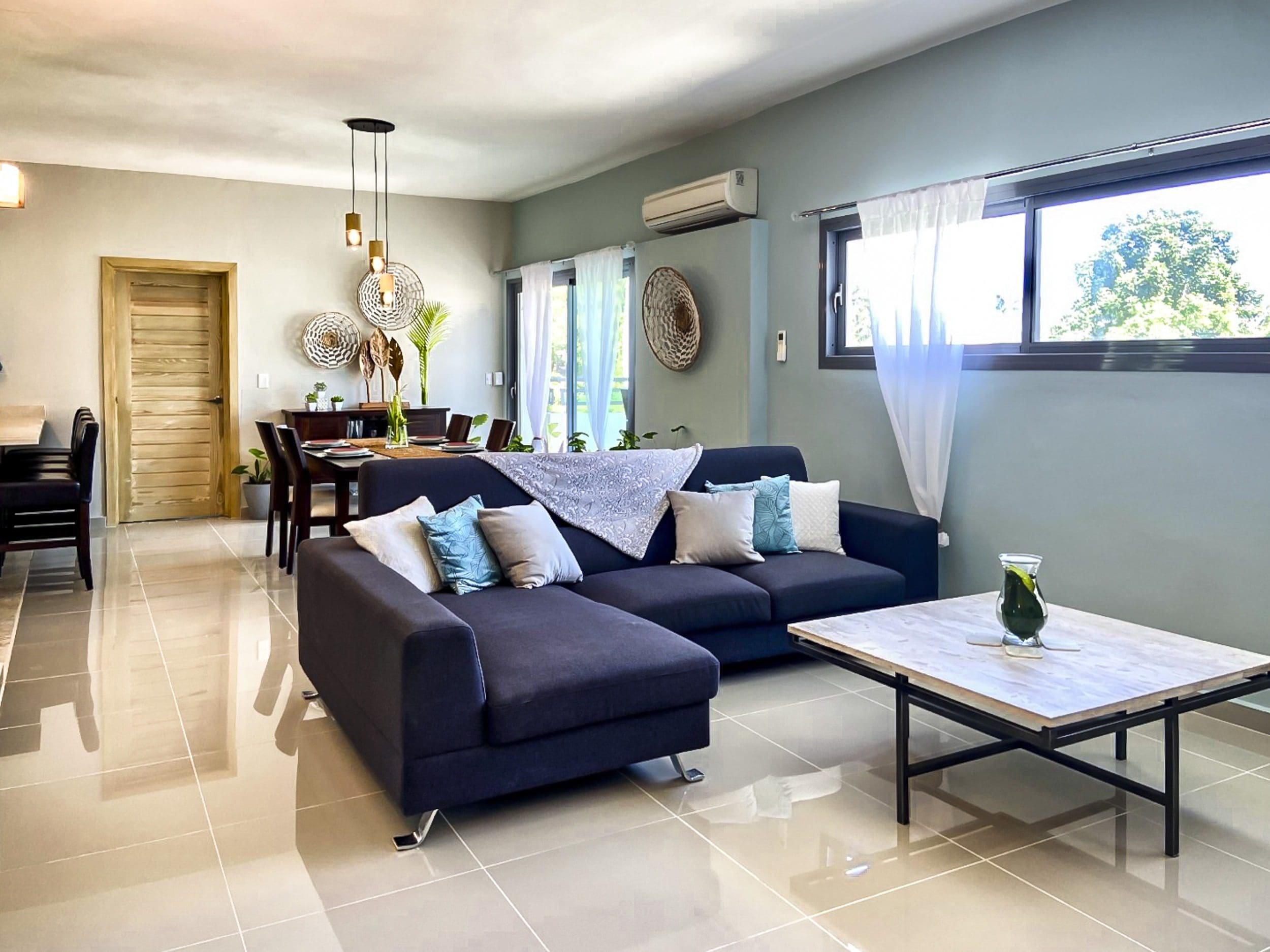 buyDRproperty Modern living room with dark blue sectional sofa and wooden coffee table. Sosua Real Estate