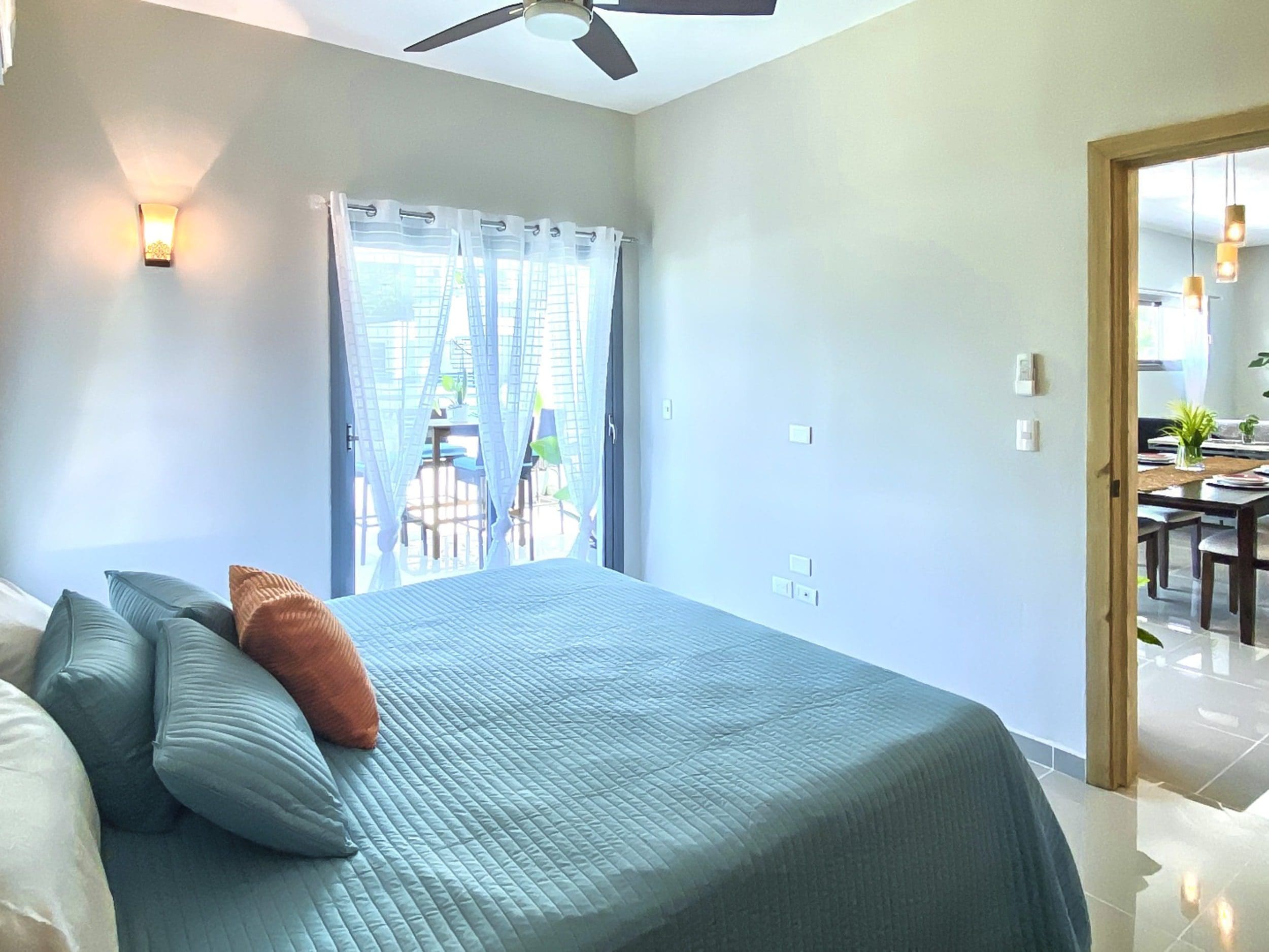 buyDRproperty Bedroom of a 2-bedroom penthouse for sale in ProCab with teal bedding and orange pillow Sosua Real Estate