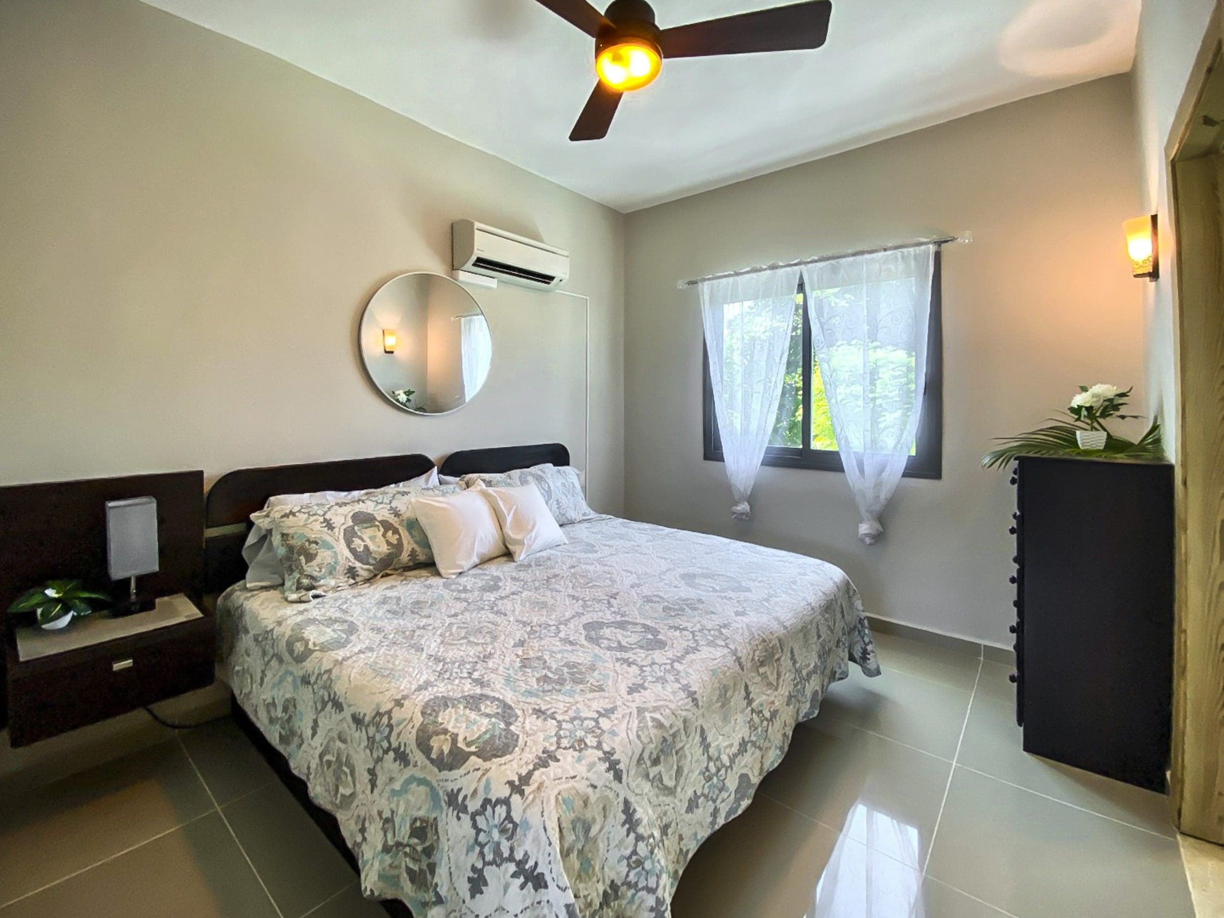 buyDRproperty Bedroom with bed, mirror, and window in a ProCab penthouse. Sosua Real Estate