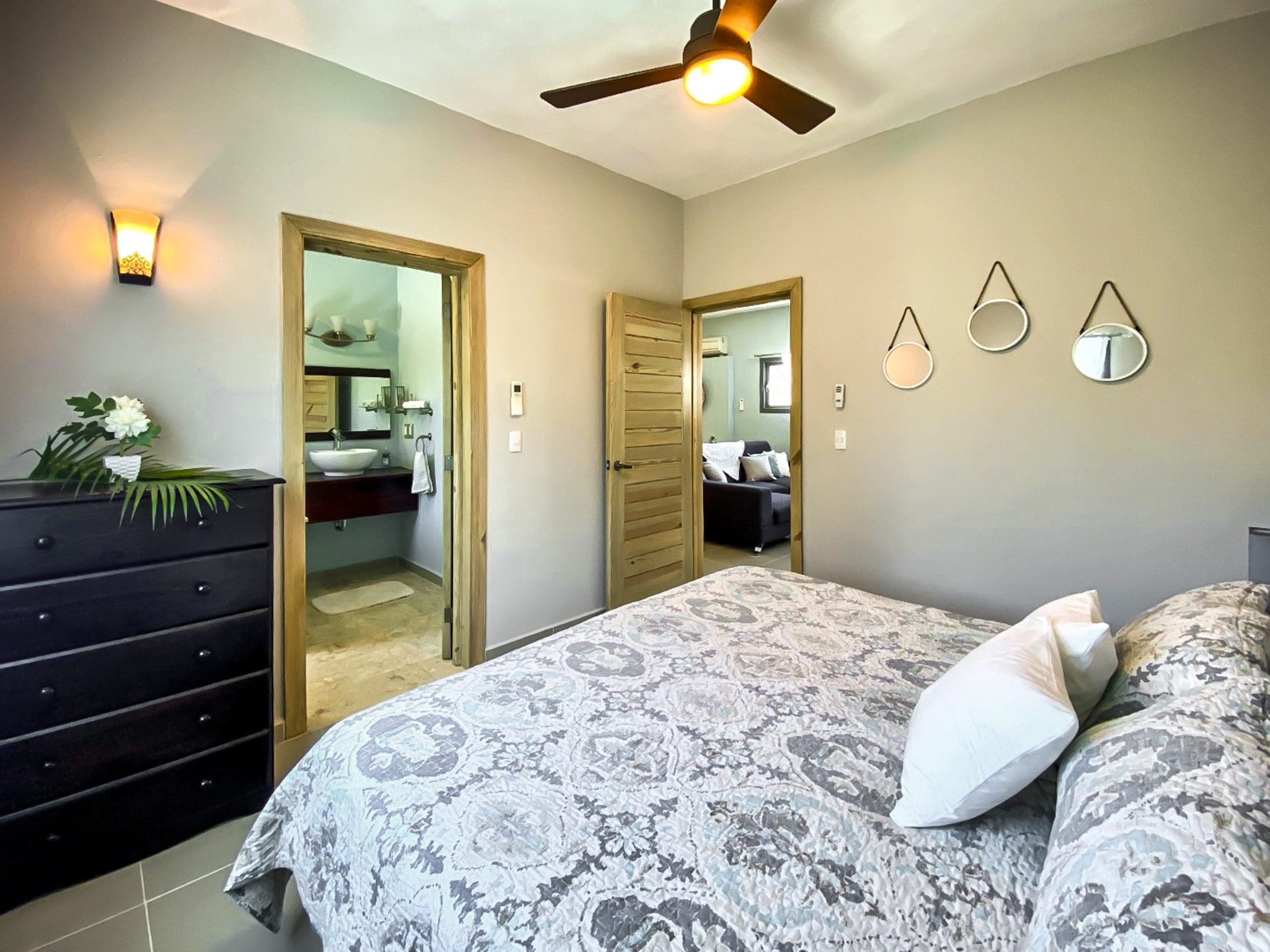 buyDRproperty Bedroom in a ProCab penthouse for sale, featuring a bed, dresser, and bathroom access. Sosua Real Estate