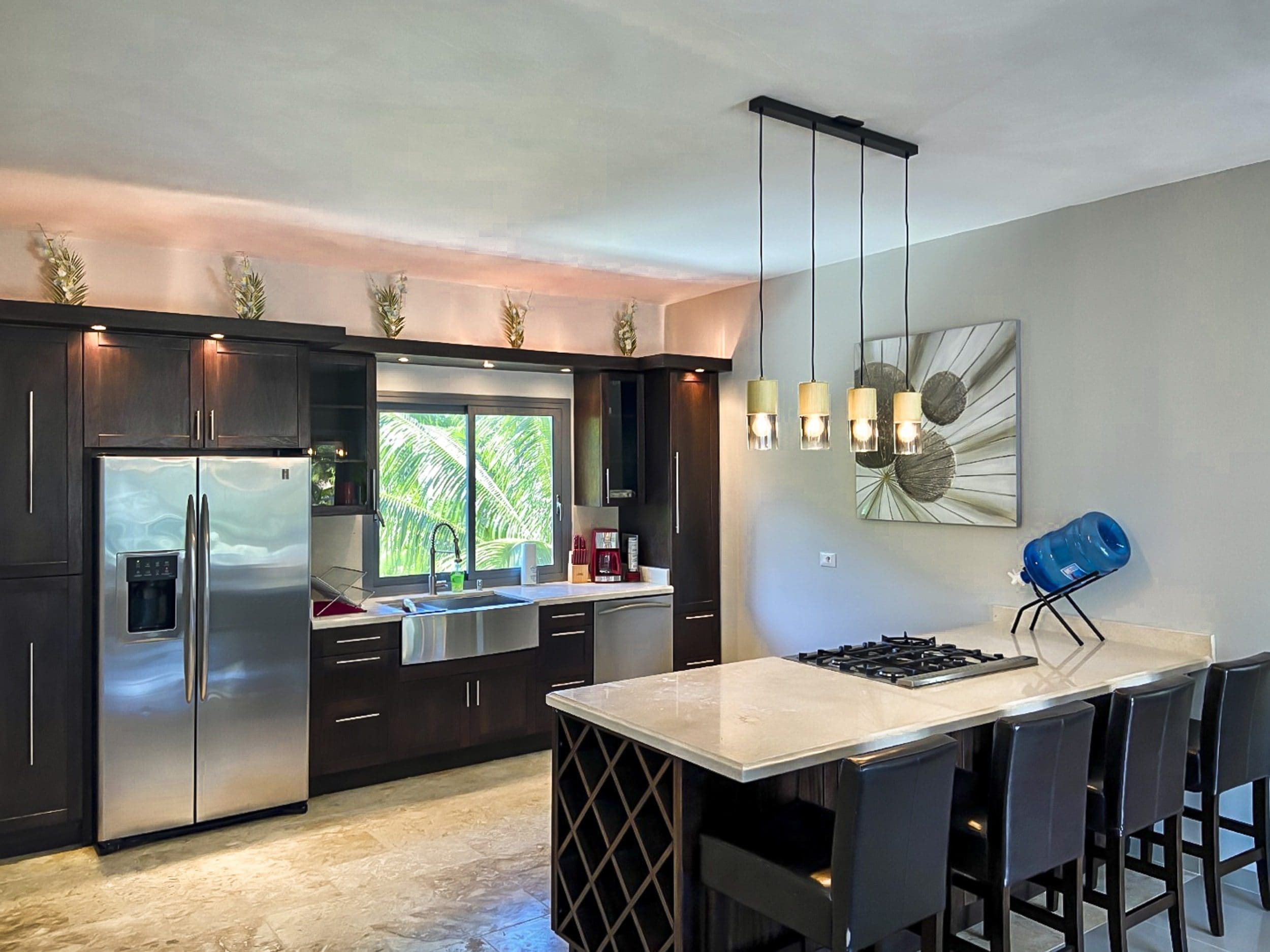 buyDRproperty Modern kitchen with dark cabinets, stainless steel appliances, and a kitchen island. Sosua Real Estate