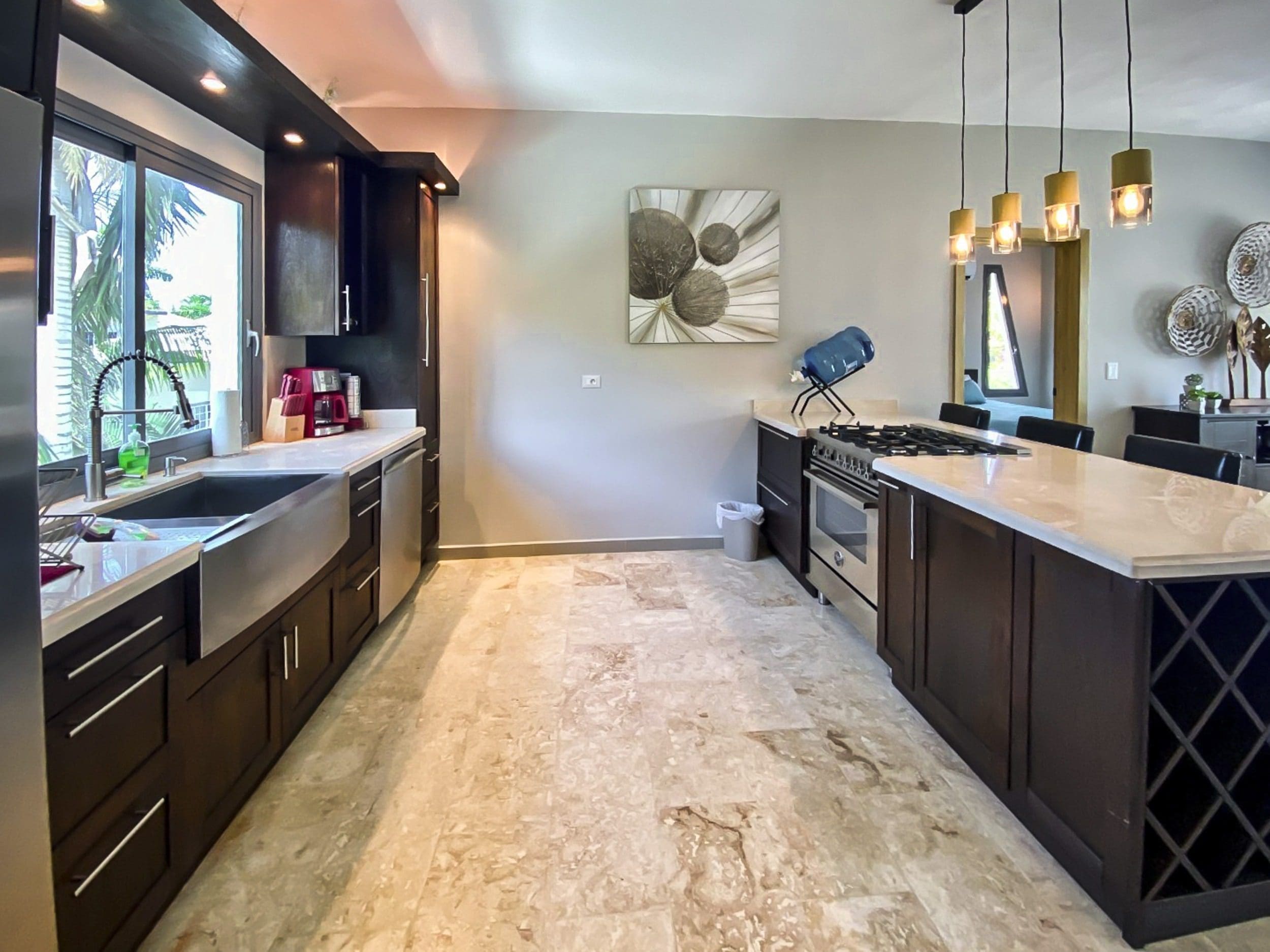 buyDRproperty Modern kitchen with dark cabinets, stainless steel appliances, and a large island. Sosua Real Estate