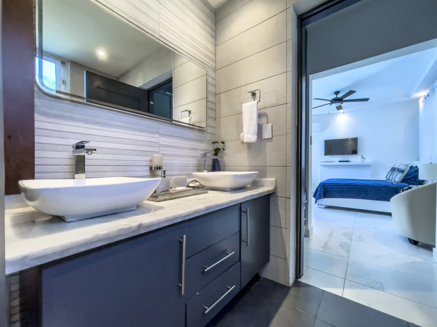 buyDRproperty Modern bathroom with dual sinks and a view into a Sosúa Ocean Village 3-bedroom villa. Sosua Real Estate