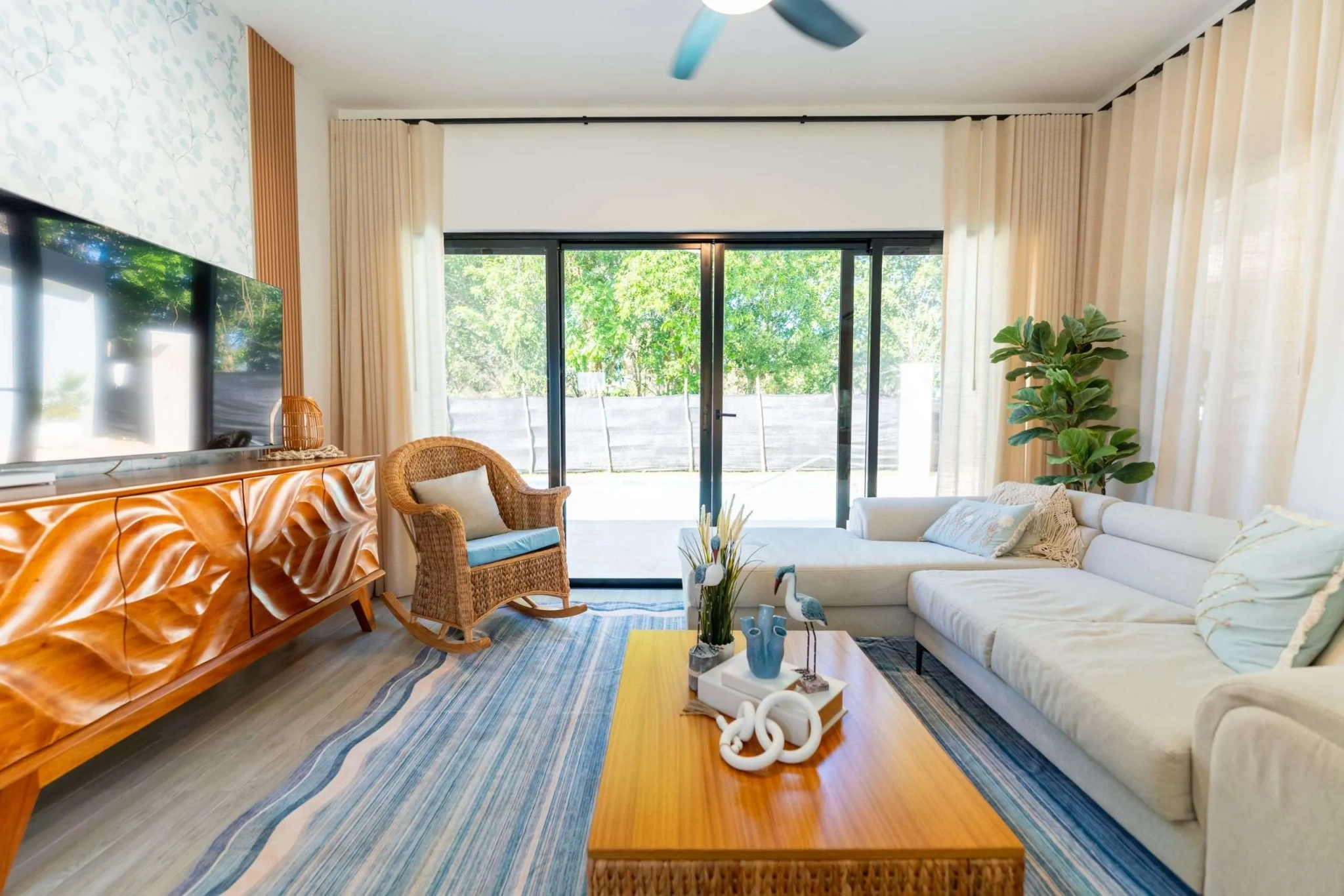 buyDRproperty Bright living room with sectional sofa, rattan chair, and ocean-themed rug Sosua Real Estate
