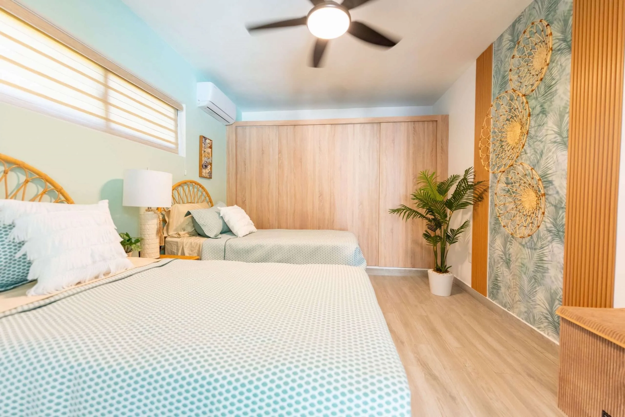 buyDRproperty Two twin beds in a tropical-themed bedroom with a large wooden closet. Sosua Real Estate
