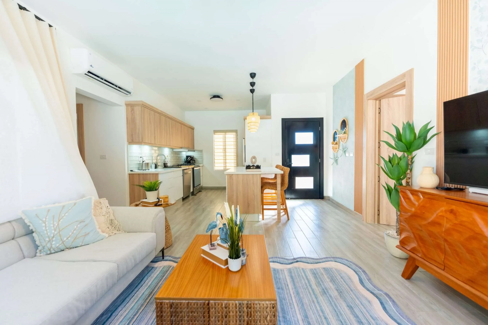 buyDRproperty Bright, modern living room and kitchen with light wood cabinets and coastal decor Sosua Real Estate