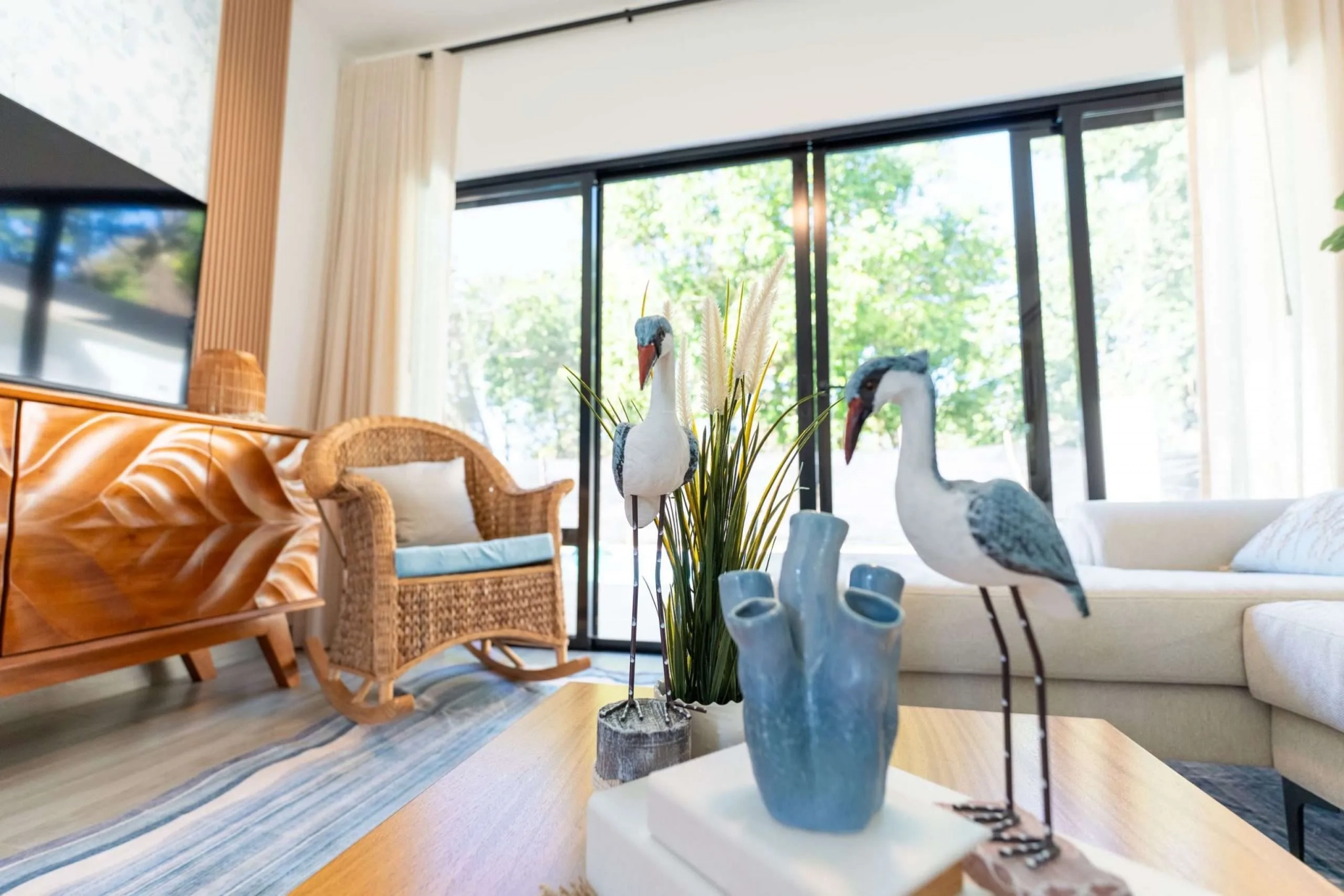 buyDRproperty Coastal living room decor with wicker chair, sofa, and bird figurines. Sosua Real Estate