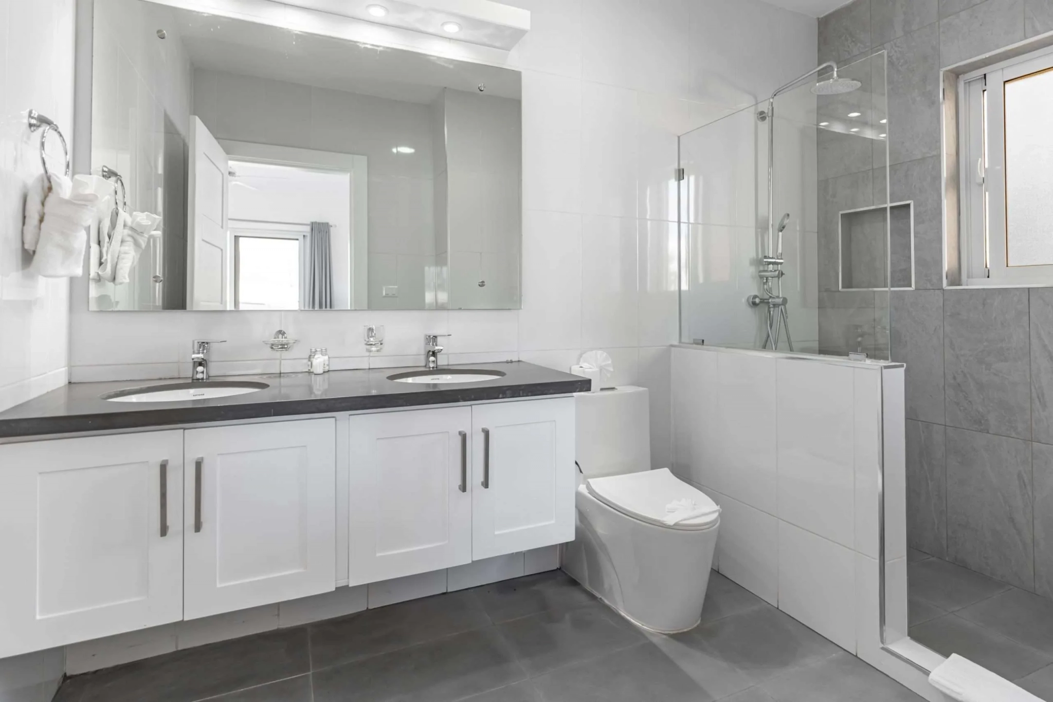buyDRproperty Modern bathroom with double vanity, toilet, and walk-in shower Sosua Real Estate