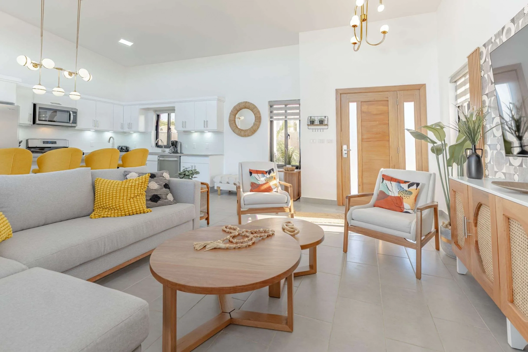 buyDRproperty Modern living room with light grey sectional sofa, wooden coffee table, and white armchairs. Sosua Real Estate