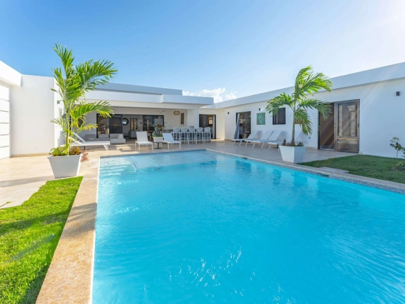 buyDRproperty Modern white villa with a bright blue swimming pool and palm trees Sosua Real Estate