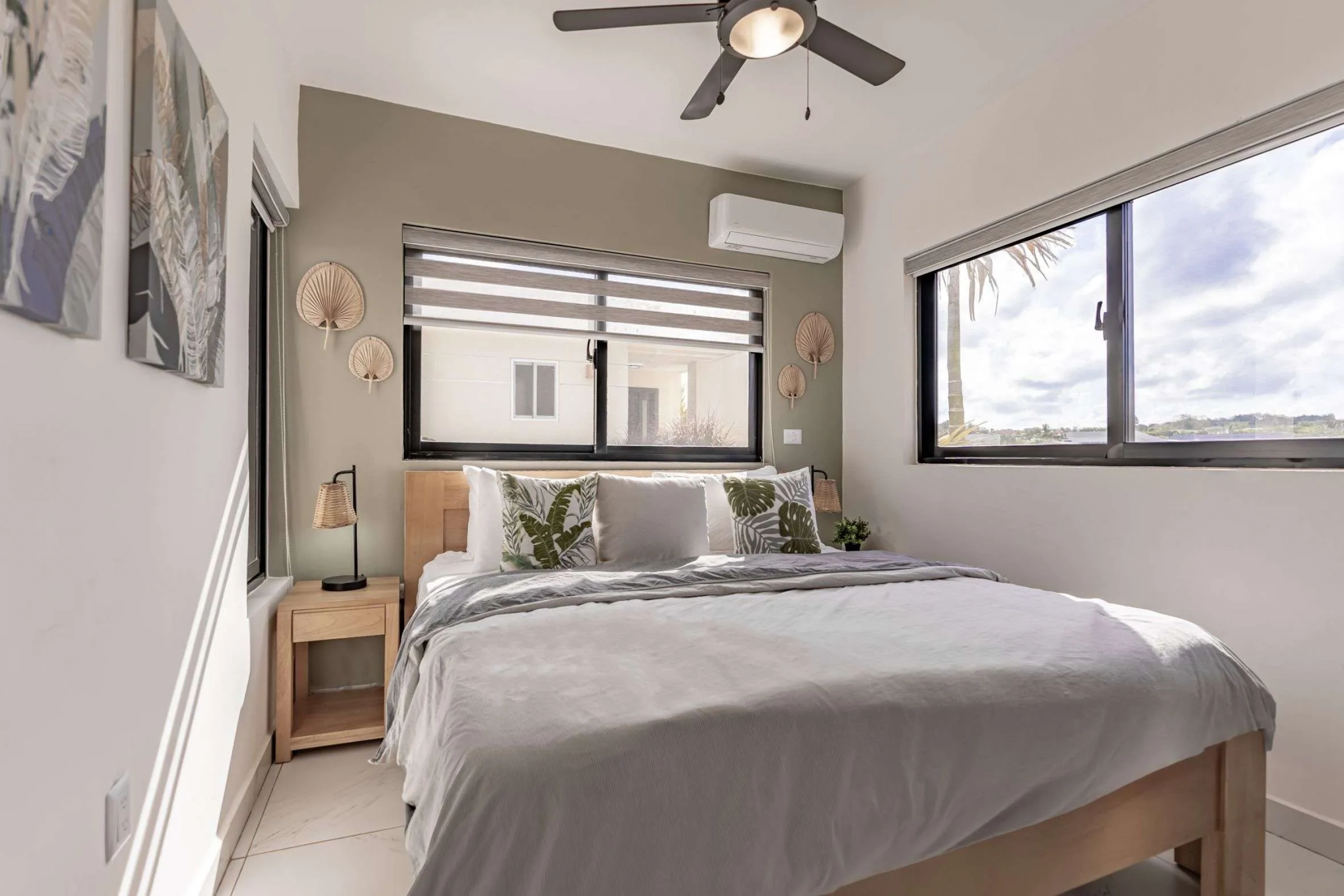 buyDRproperty Modern bedroom with king-size bed, tropical pillows, and large windows. Sosua Real Estate