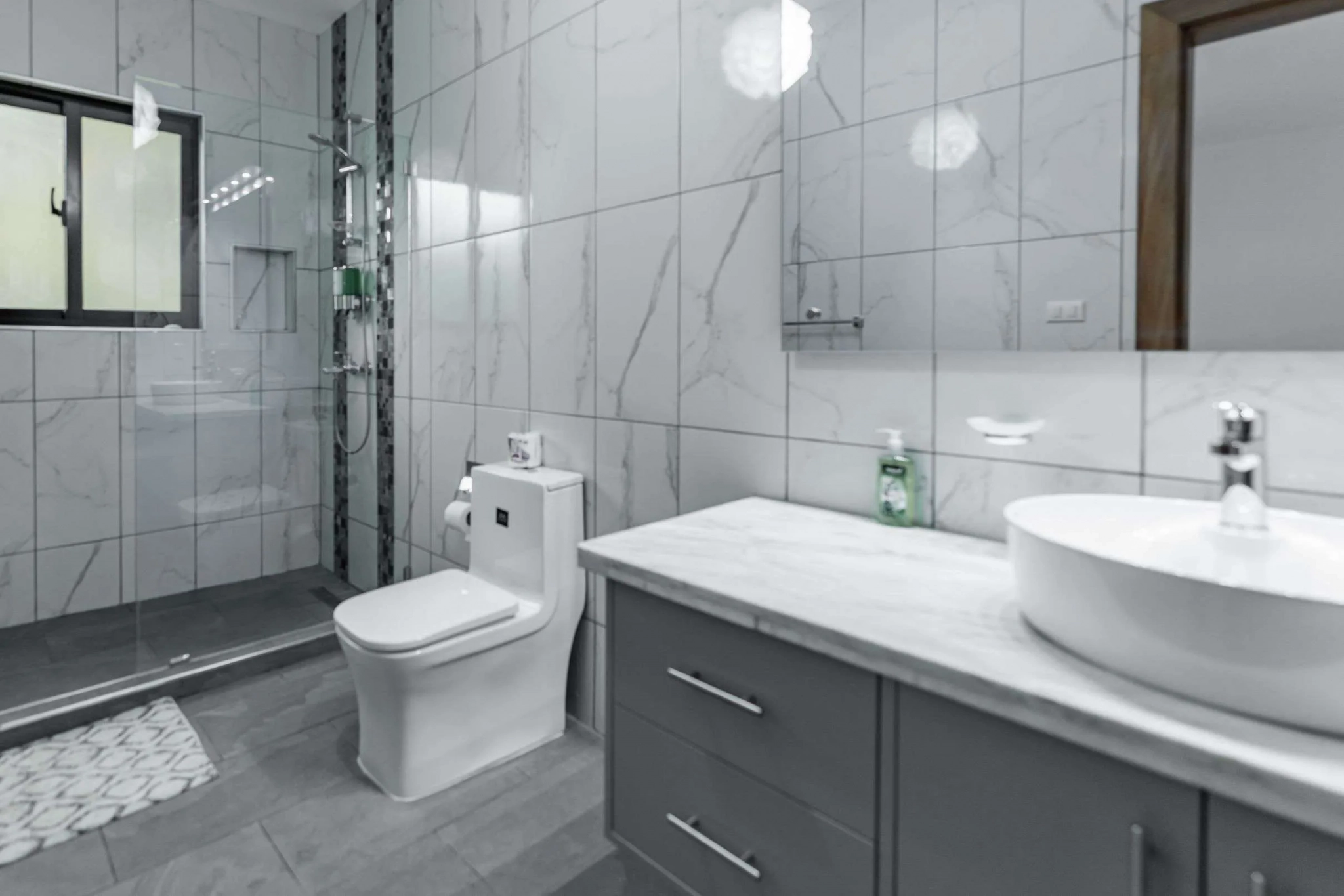 buyDRproperty Modern marble bathroom with a white toilet and vanity. Sosua Real Estate