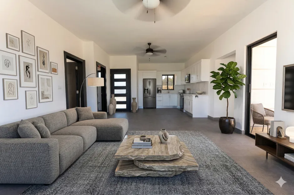 buyDRproperty Modern living room with sectional sofa, abstract art, and open-plan kitchen Sosua Real Estate