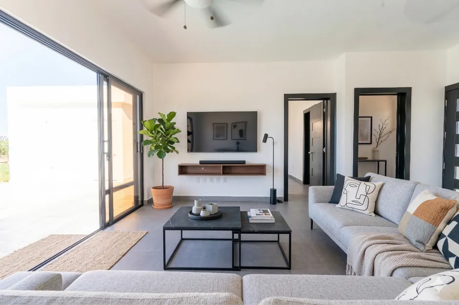 buyDRproperty Modern living room with large sliding glass doors, gray sofa, and coffee table Sosua Real Estate