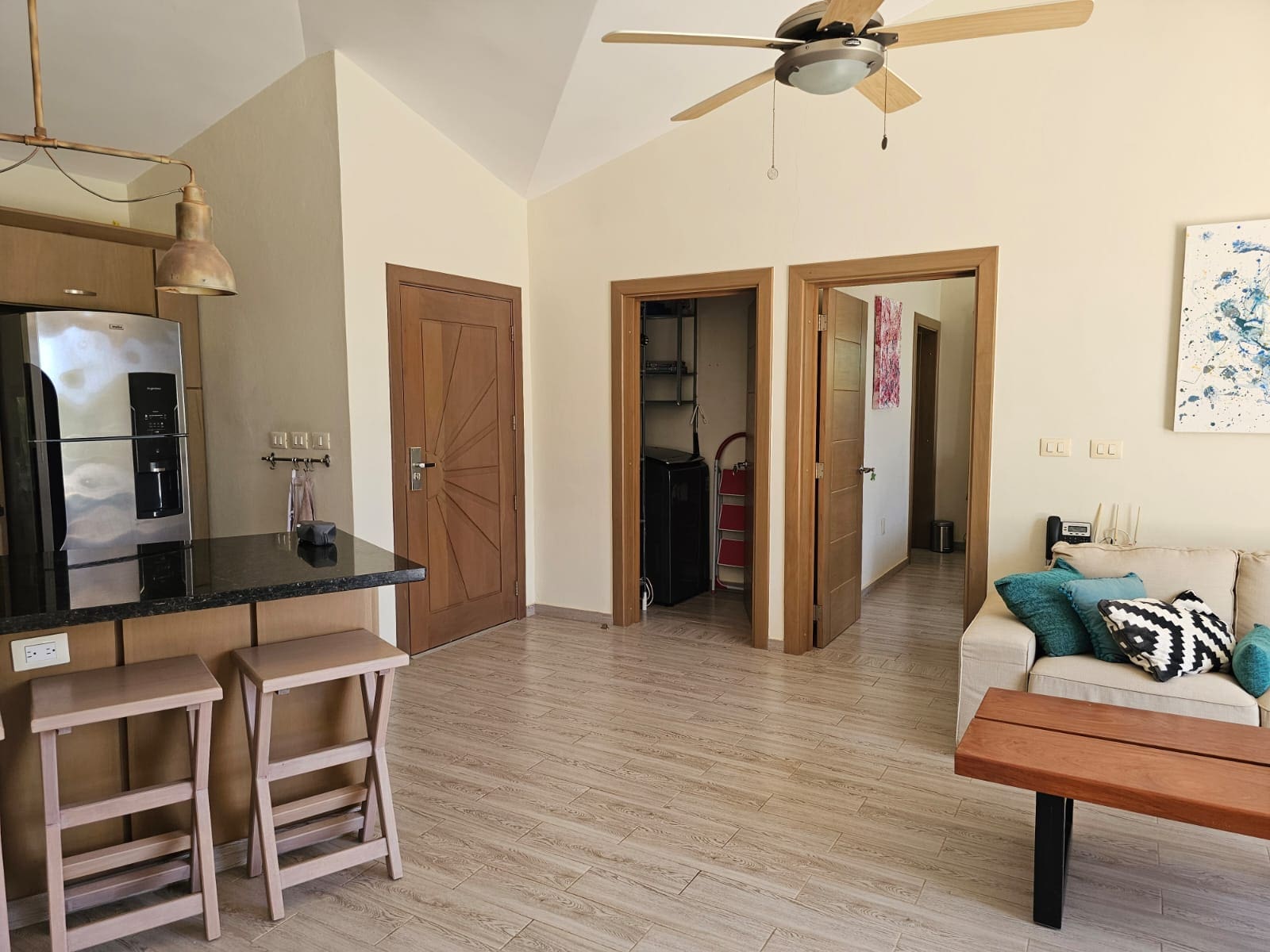 buyDRproperty Modern kitchen and living area with stainless steel refrigerator, island, and sofa. Sosua Real Estate