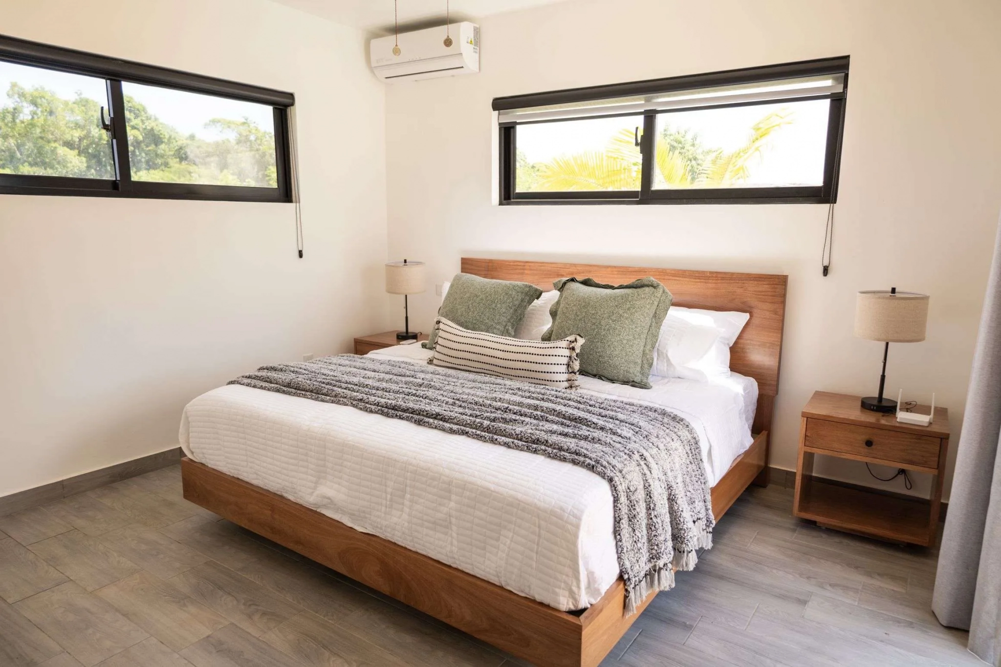 buyDRproperty Modern bedroom with a queen bed, wooden furniture, and large windows Sosua Real Estate