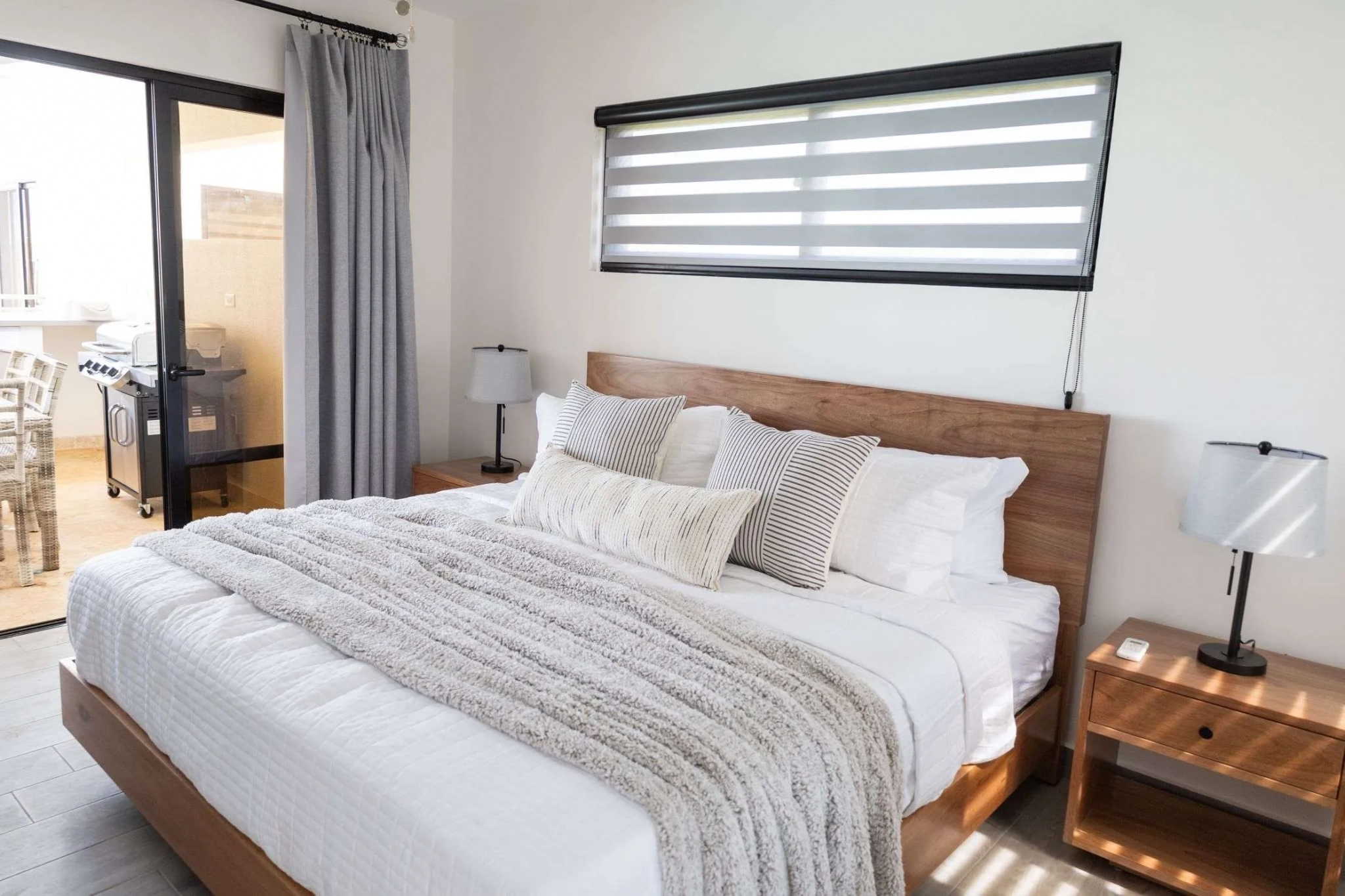 buyDRproperty Modern bedroom with king-size bed, white linens, and wooden nightstands Sosua Real Estate