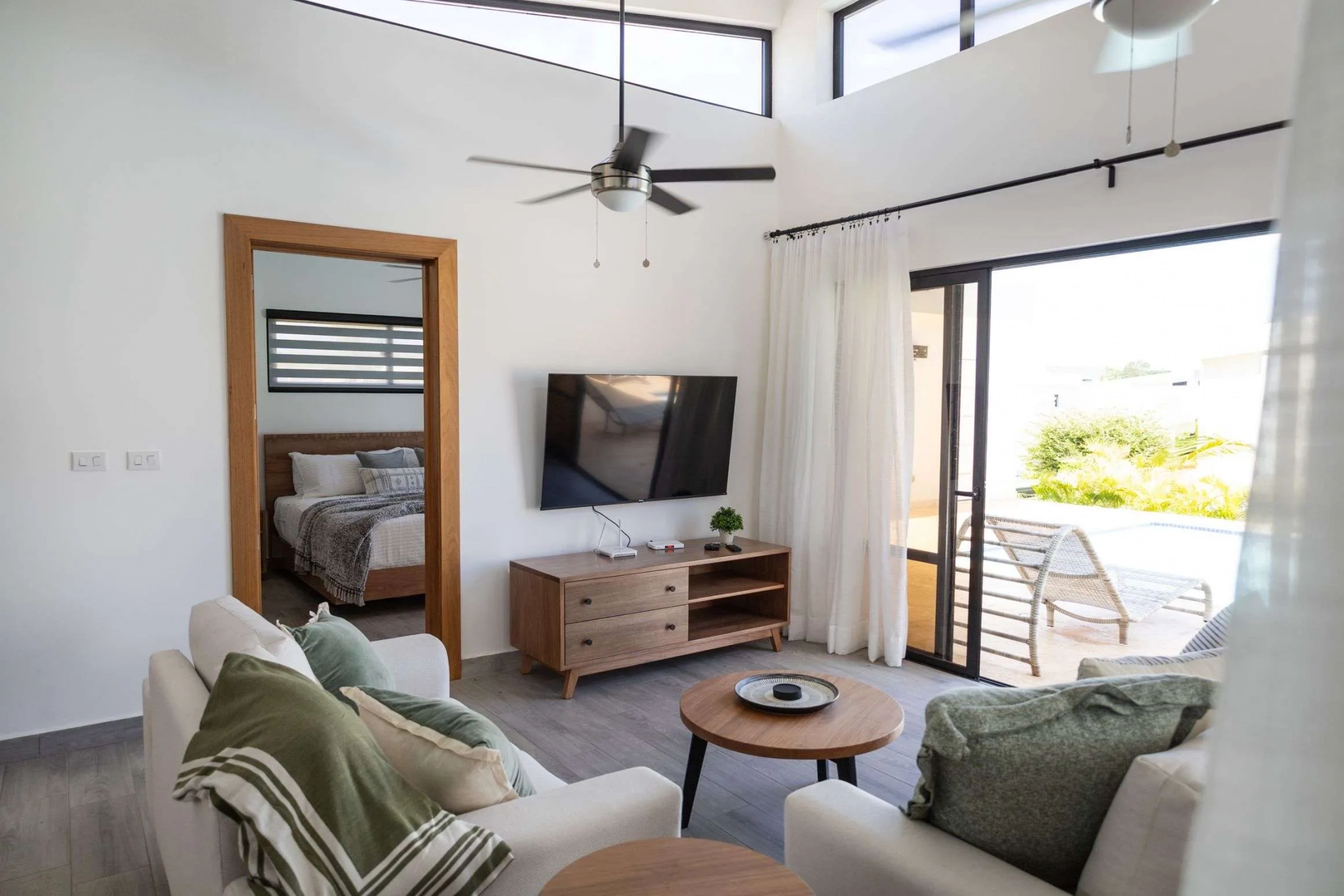 buyDRproperty Modern living room with white couches, TV, and view of a pool Sosua Real Estate