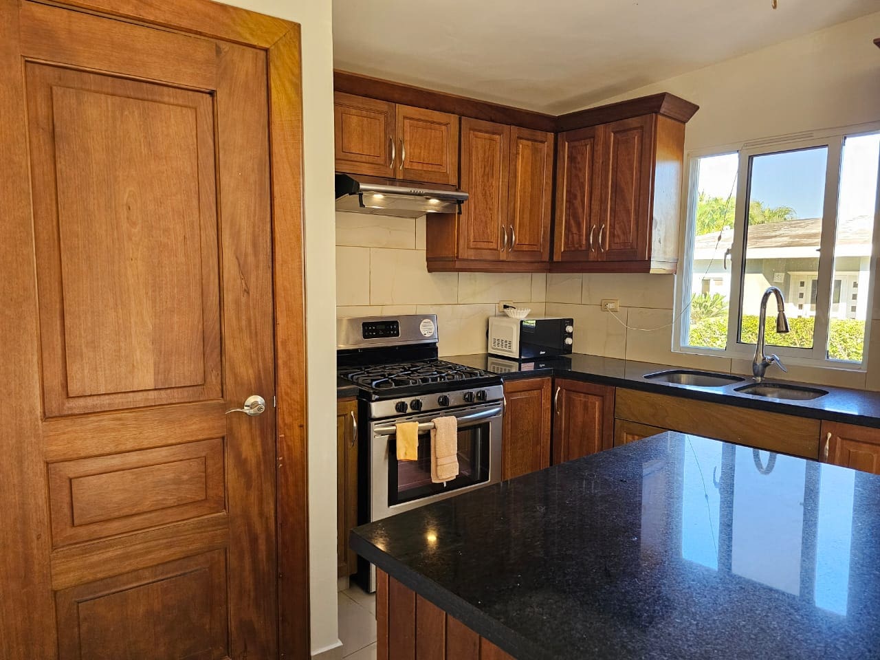 buyDRproperty Casa Linda Villa kitchen with stainless steel stove and dark granite countertops. Sosua Real Estate