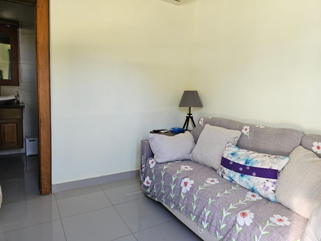 buyDRproperty Cozy living room in a Casa Linda Villa with floral sofa and lamp. Sosua Real Estate