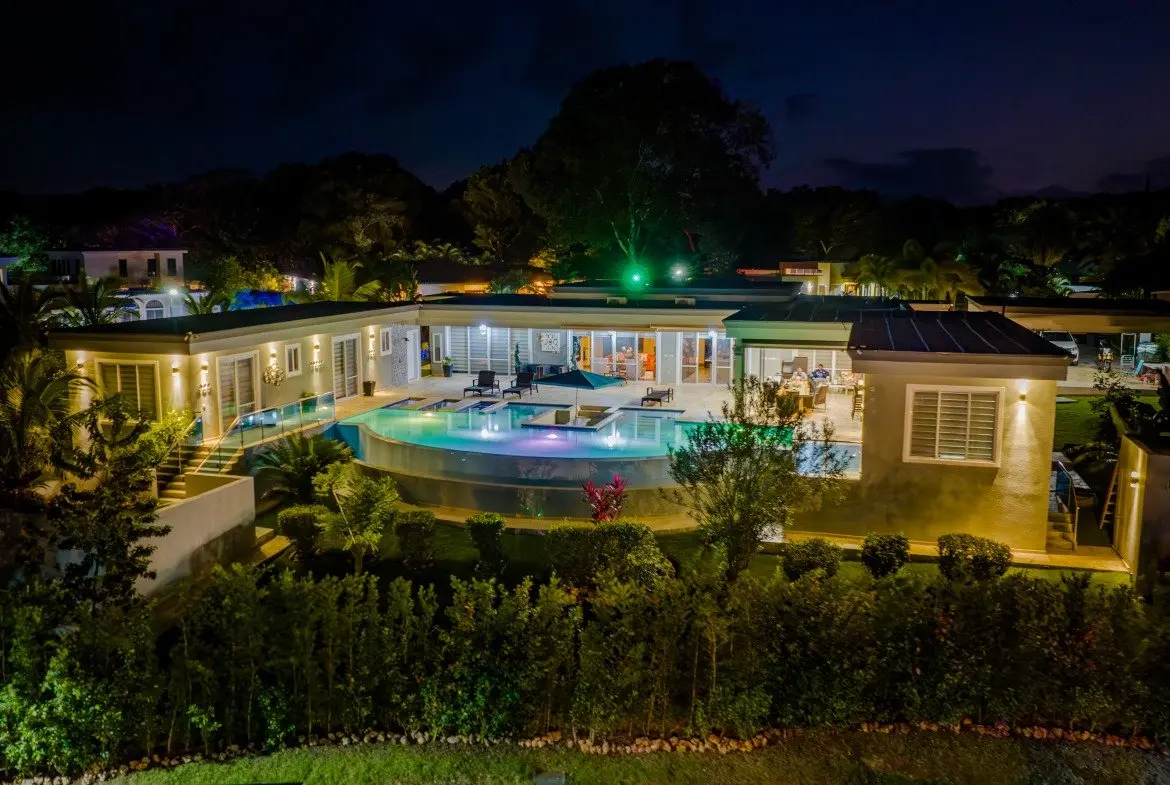 buyDRproperty Luxury villa with infinity pool at night, tropical landscape Sosua Real Estate
